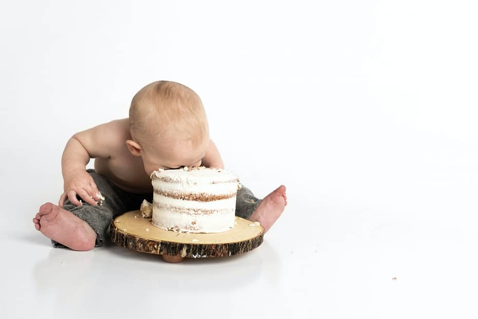 "What's in it for me?" a baby has his face in cake