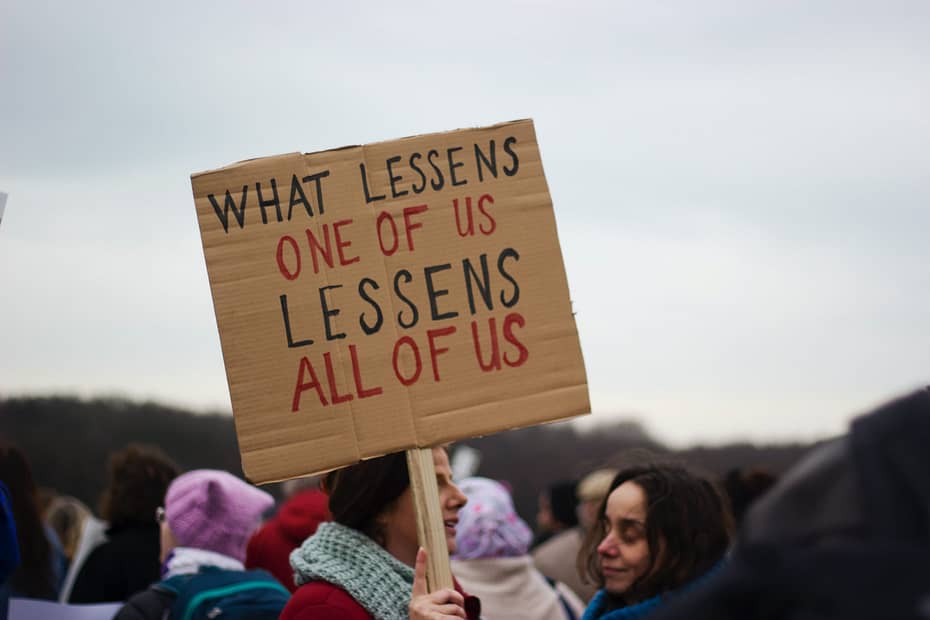 a sign saying "what lessens one of us lessens all of us"